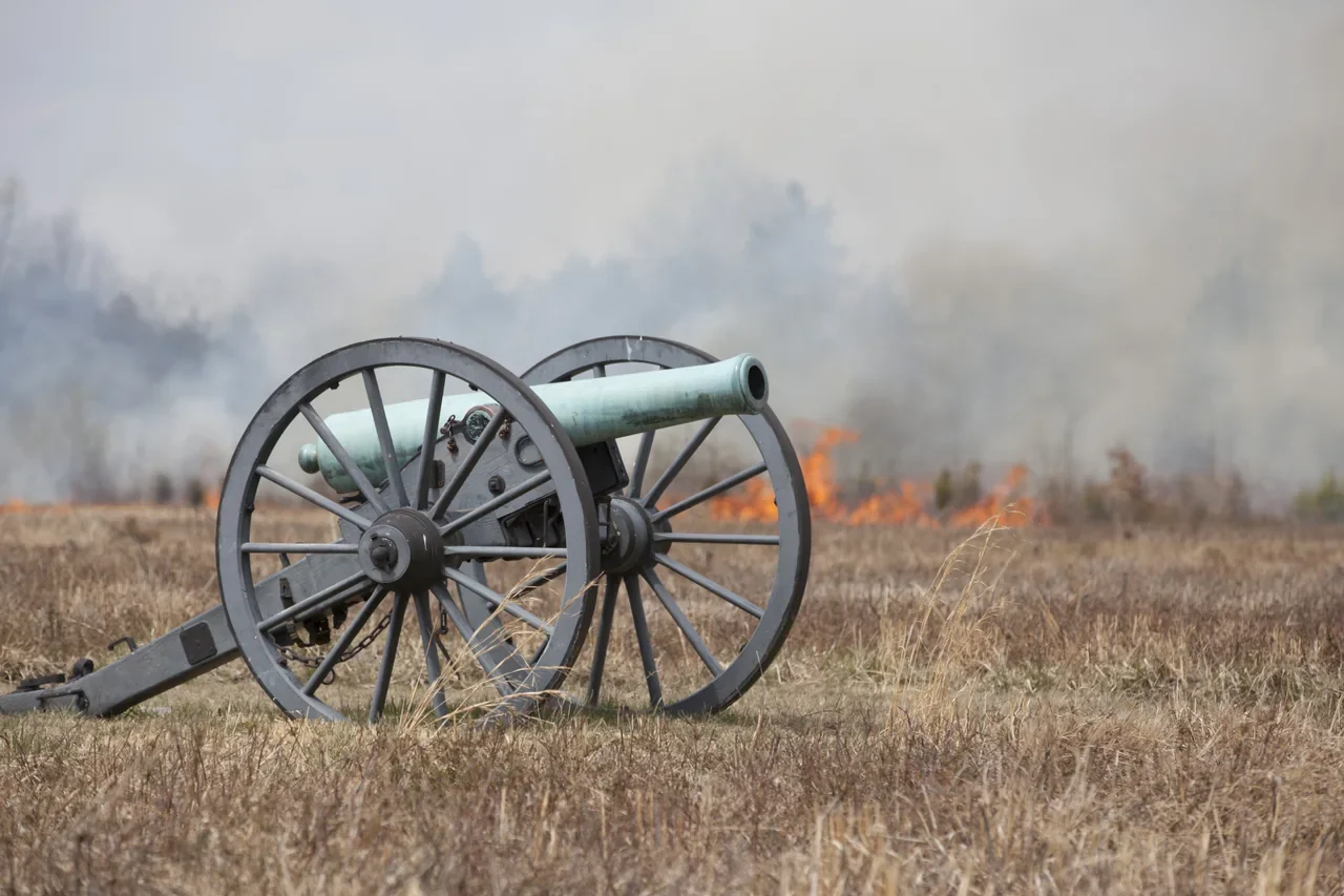 Historical cannon near Brawner Farm with fire and smoke from an archived prescribed burn