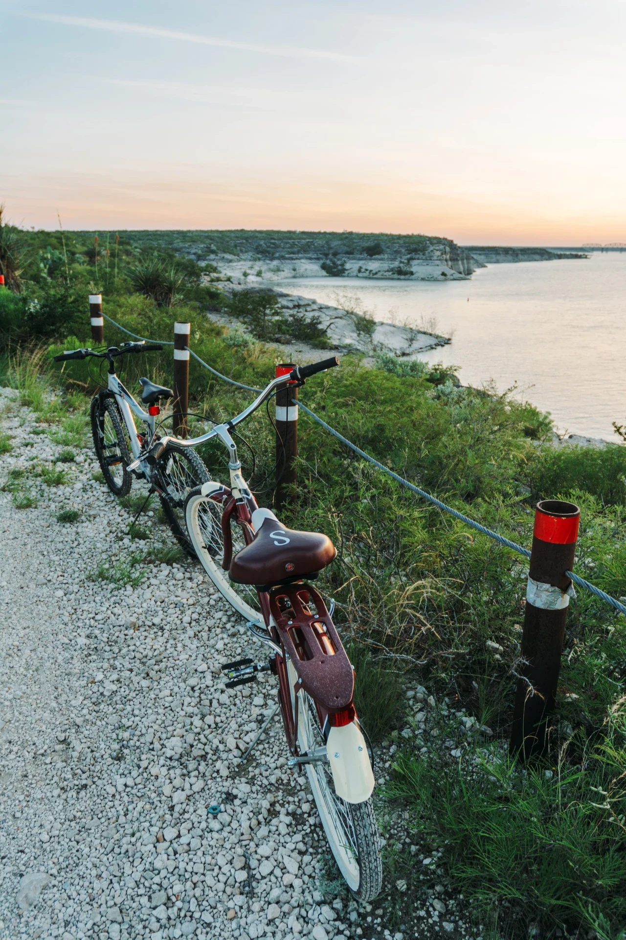 Two bicycles beside a gravel shoreline path at Amistad, NPS archive