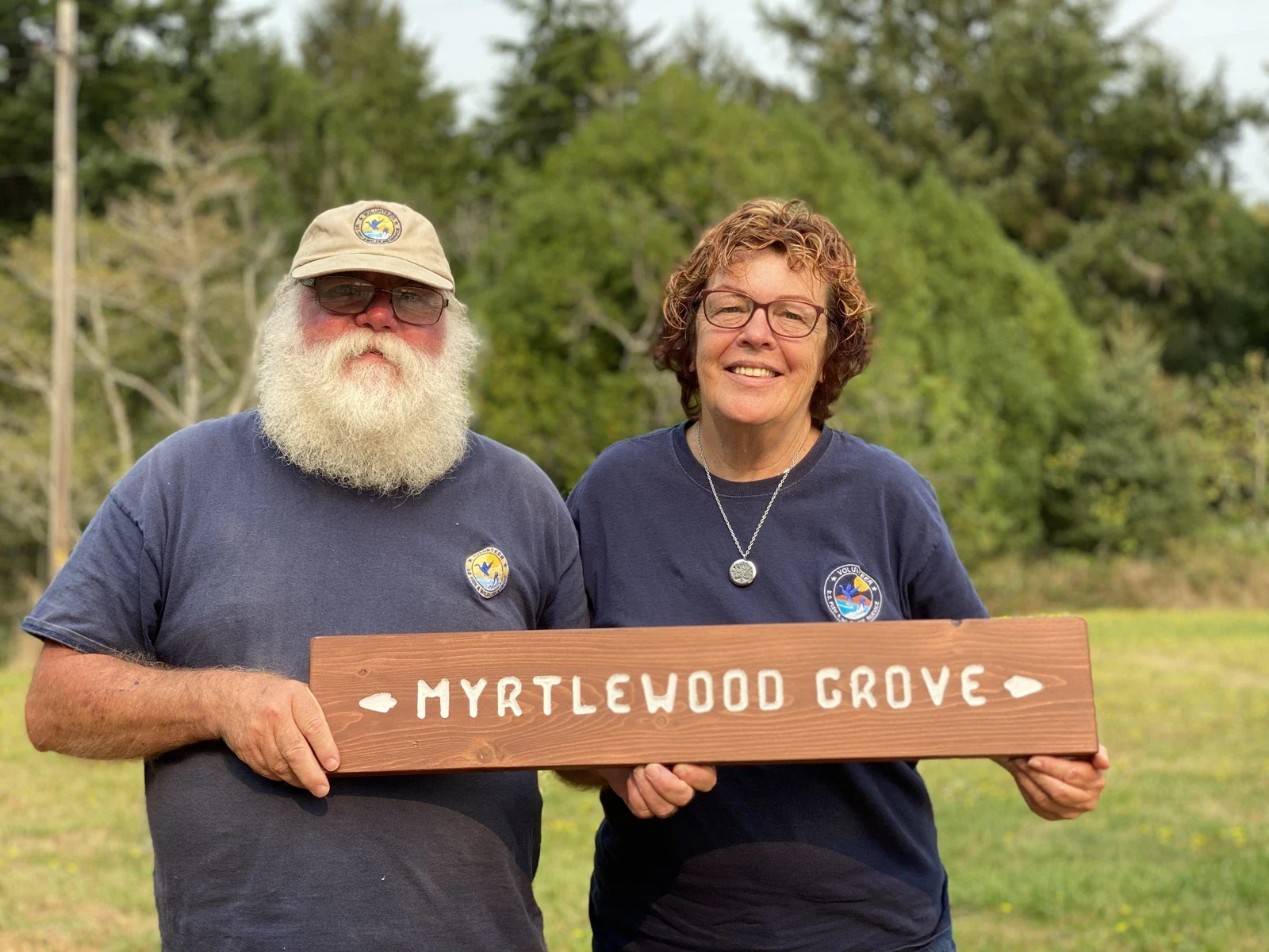 Archive portrait of Bandon Marsh volunteers with a Myrtlewood Grove sign