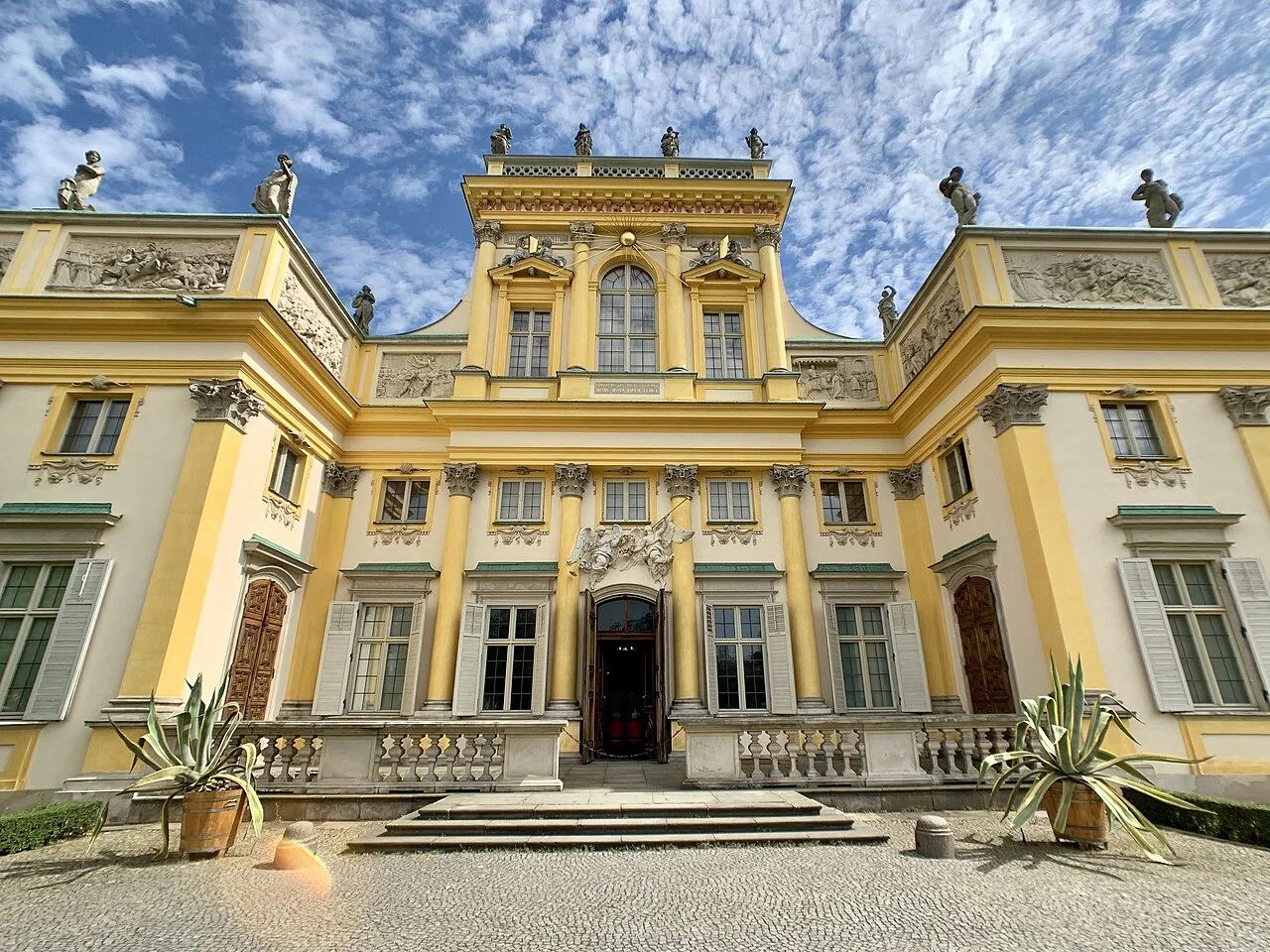 Yellow front facade and historic ornament at Wilanów Palace, Warsaw; August 2019.