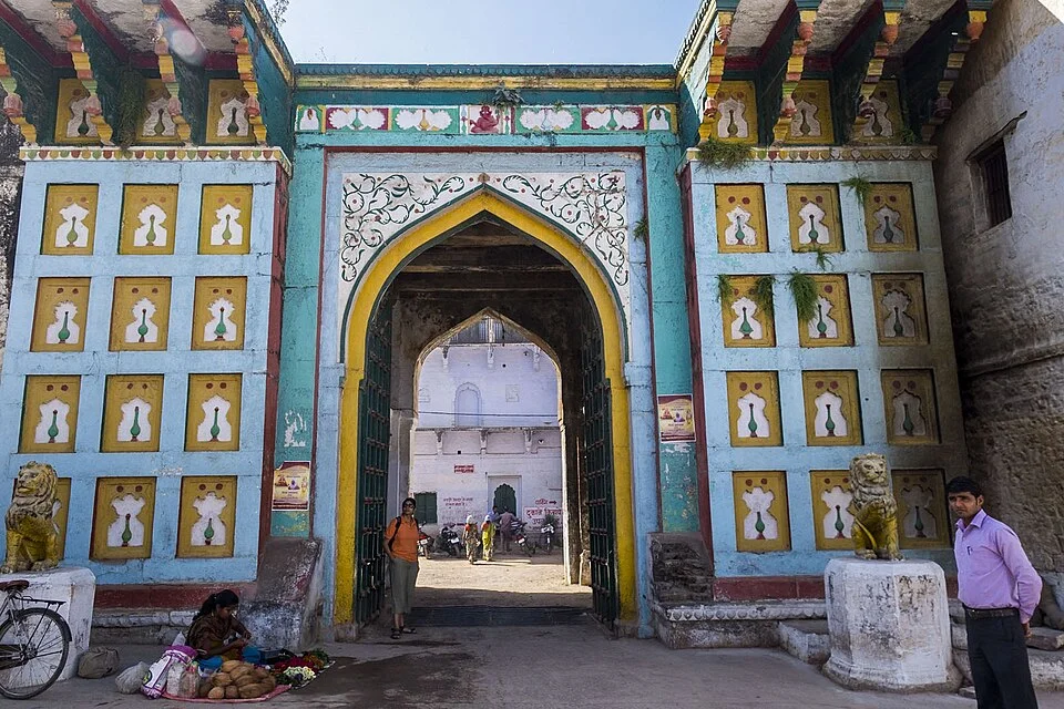 Colourful arched gateway and street approach of the building recorded as Rewa Fort