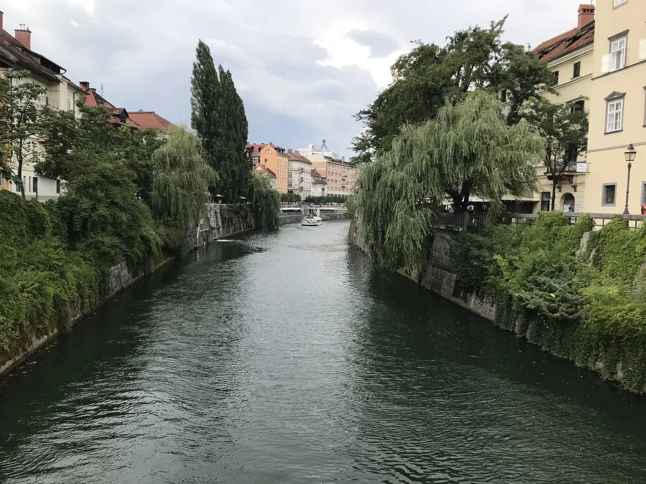 Ljubljanica nehri boyunca ağaçlar, kıyı binaları ve tekne, Ağustos 2018