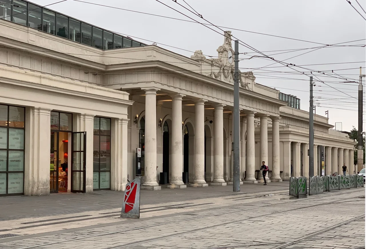 Historic colonnaded facade of Montpellier Saint-Roch station and tram wires, June 2019