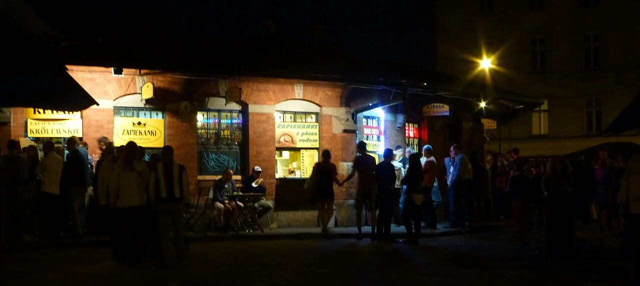Night-time food stalls and visitors around Plac Nowy in Kazimierz, Kraków; June 2013 archive photograph.