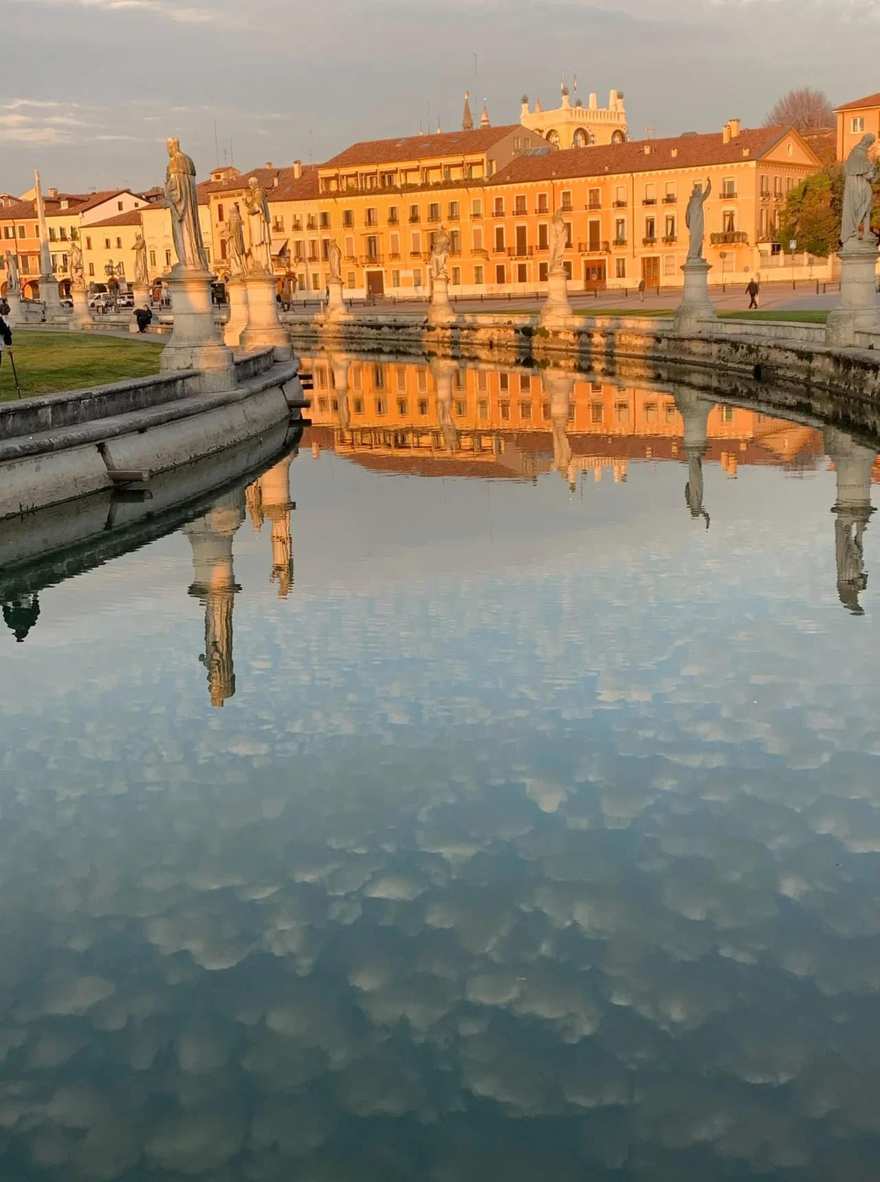 Padova Prato della Valle’de gün batımında tarihî heykeller ve kanaldaki yansımalar, Kasım 2020