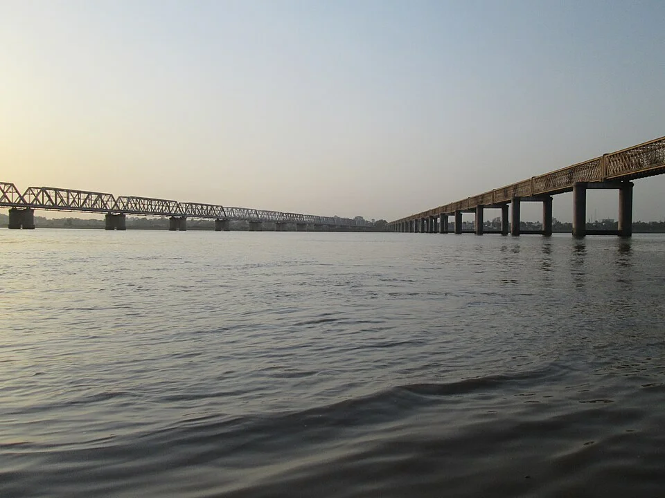 Narmada water surface near Bharuch with bridges extending towards the opposite bank