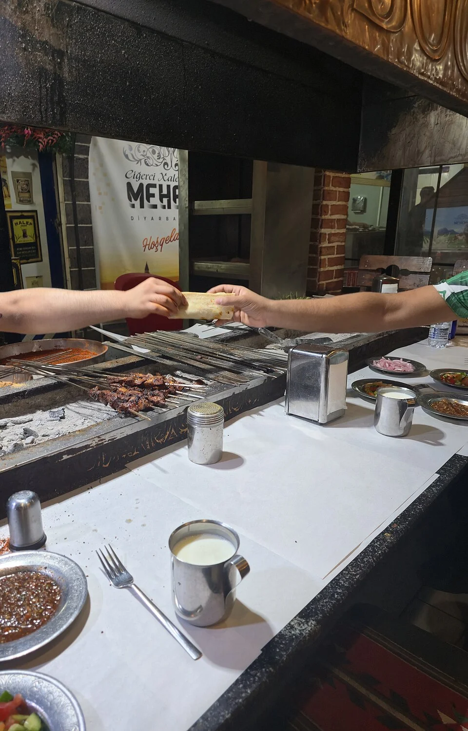 A grill and liver-food setting in Diyarbakır, June 2025; people appear in food context, not as current-service evidence or endorsement.