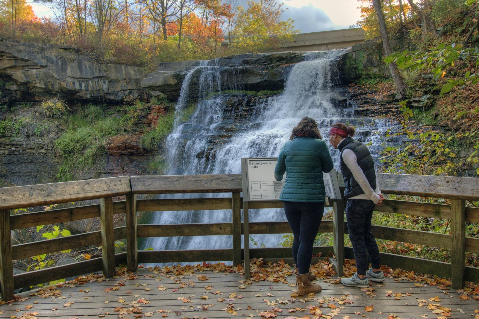 Brandywine Falls seyir alanında iki ziyaretçi ve kayalık şelale