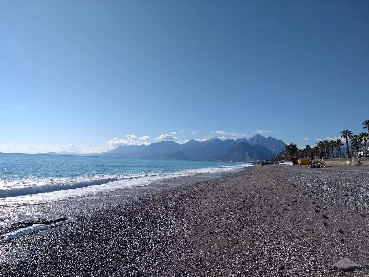 Antalya Konyaaltı kıyısında deniz ve dağ ortamı, Aralık 2021; kış arşiv fotoğrafı, güncel plaj hizmeti veya restoran düzeni değildir.