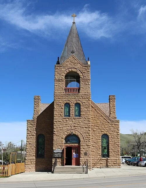 Rapid City Immaculate Conception tarihî yapısının taş cephesi, sivri çatı ve giriş basamakları