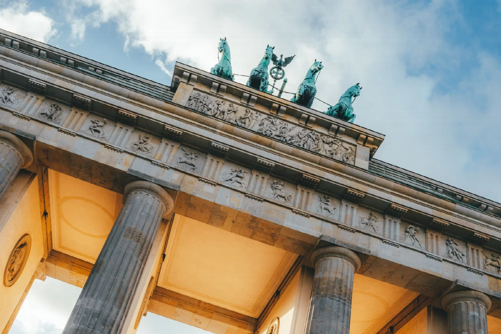 Berlin Brandenburg Kapısı ve mavi gökyüzü altında sütunlu cephesi