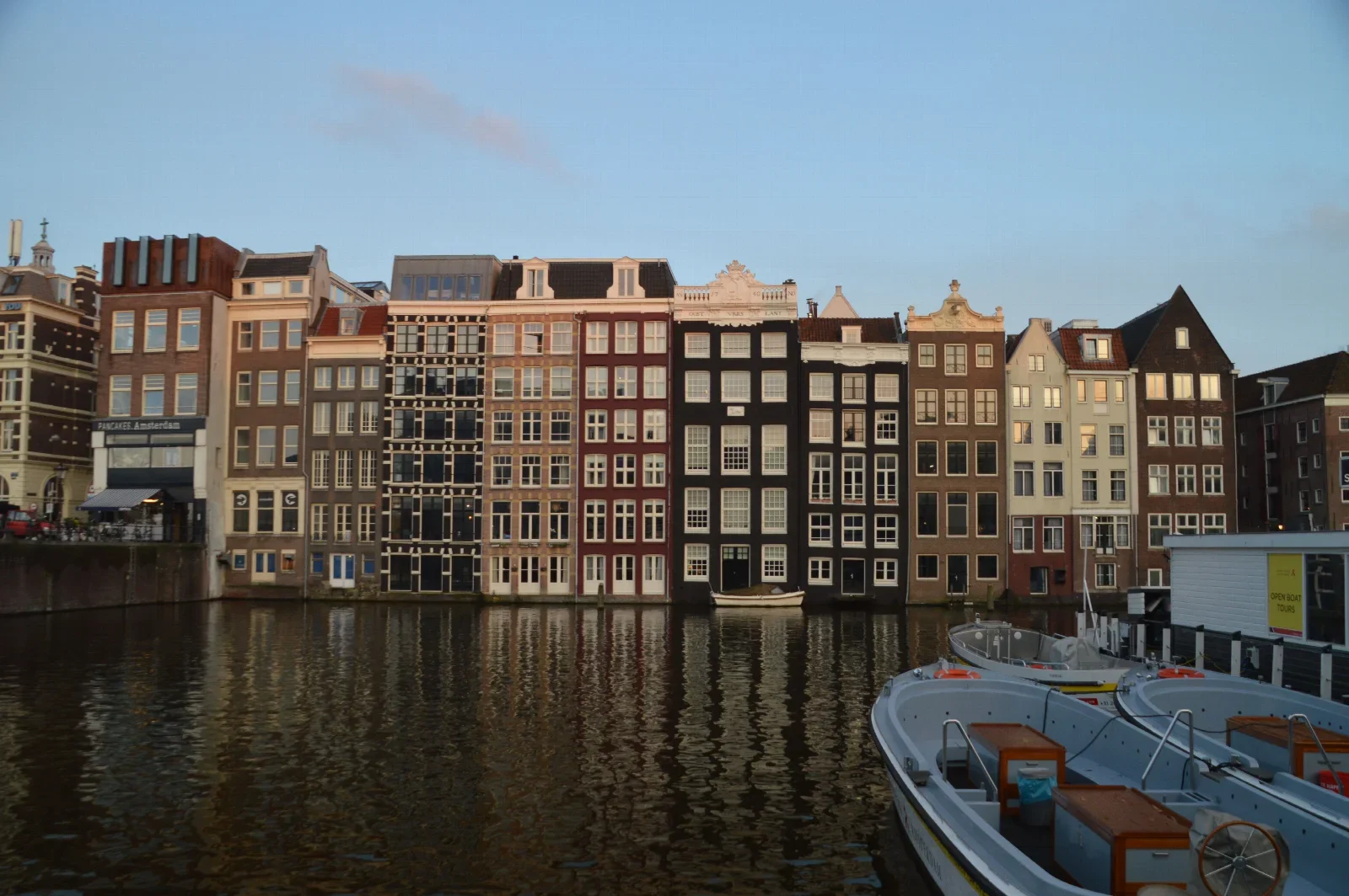 Amsterdam canal houses and reflections; real food-itinerary city context, not a rijsttafel dish or restaurant.