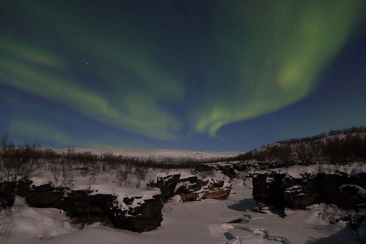 Abisko Abiskojåkka kıyısında kar ve kuzey ışıkları; gece arşiv görüntüsü, gündüz patika koşulu değildir; Pavel.shyshkouski, 2017-03-07.