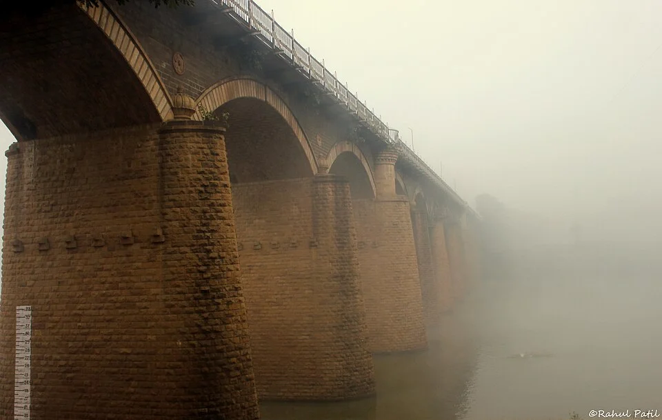 Stone piers and an underside arch view of Irwin Bridge in Sangli