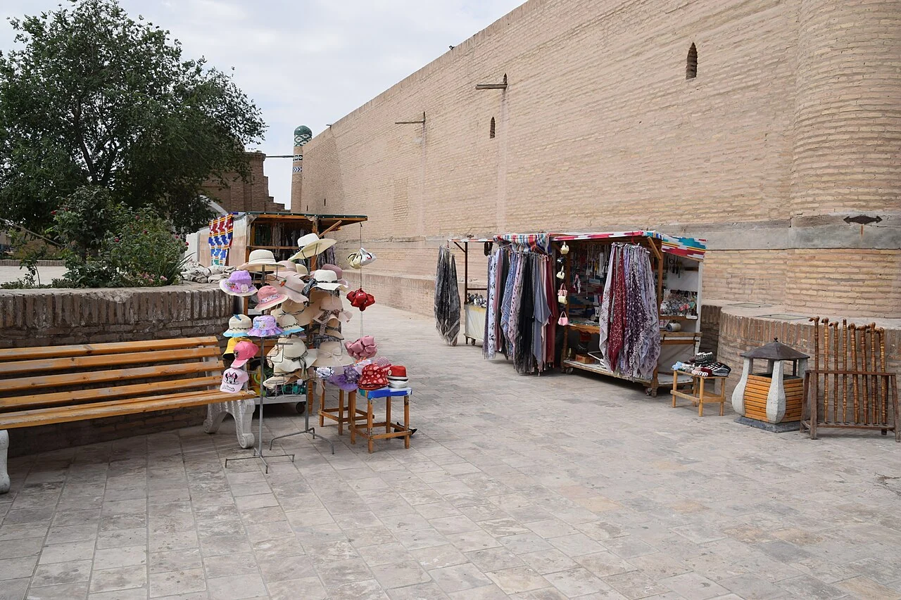 Trading and pedestrian setting beside a Khiva wall; June 2023, not a transport timetable