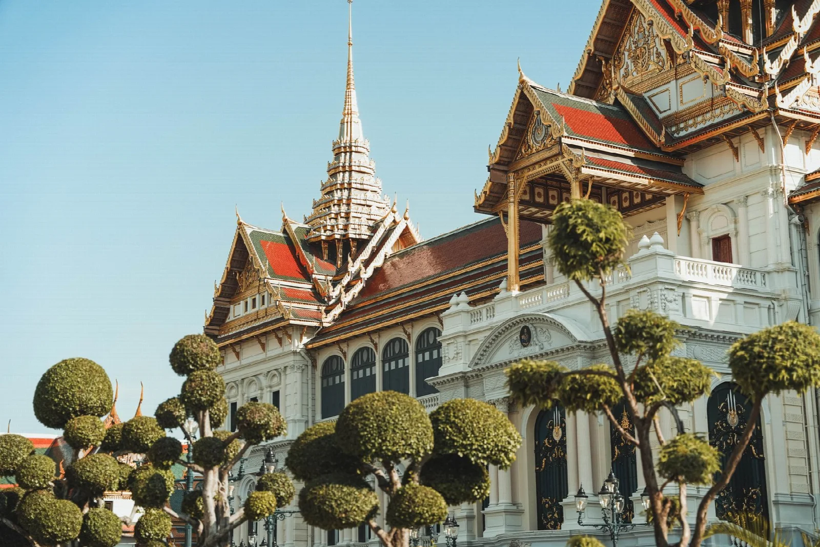 Bangkok Grand Palace avlusunda süslü saray yapıları ve ağaçlar