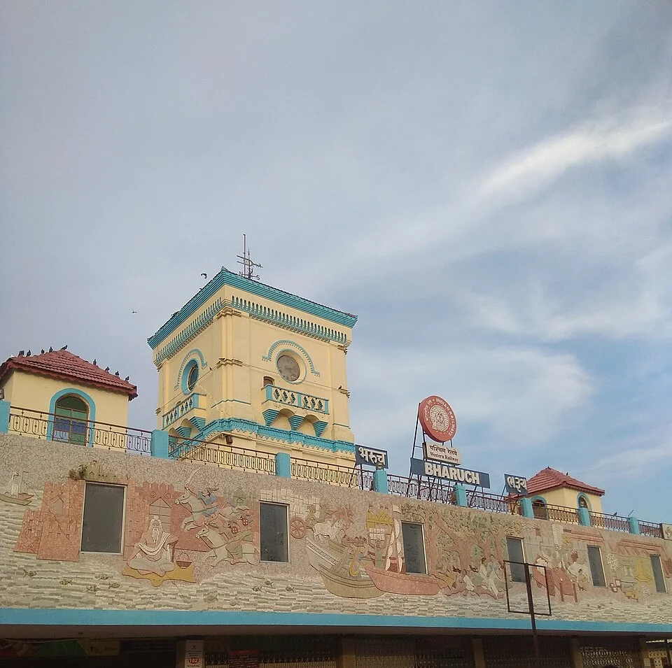 Coloured station entrance frontage with a clock tower in Bharuch