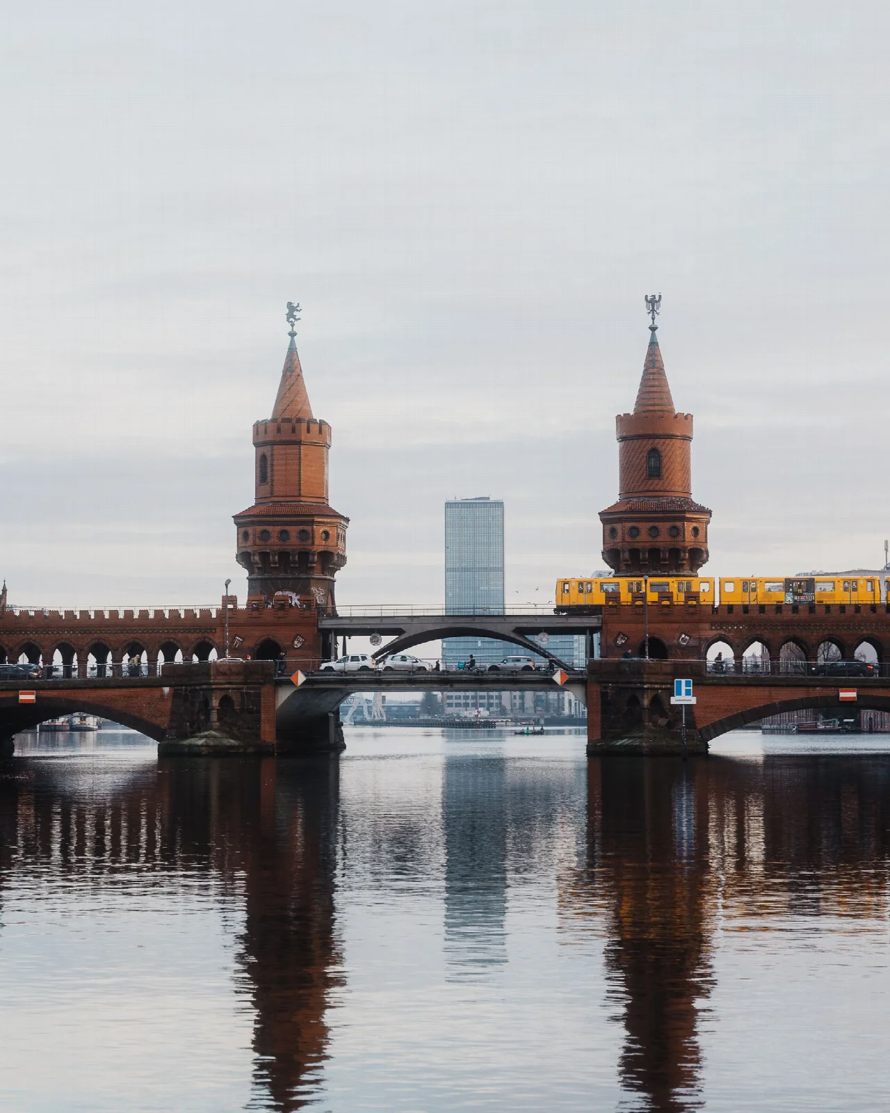 Oberbaum Bridge over the Spree with a yellow train and reflections on the water