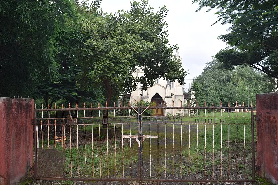 Exterior grounds of Our Lady of Health Church behind its fence in Satara