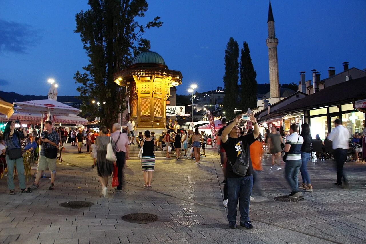 Sebilj and evening visitors in Baščaršija square, August 2019; not a current restaurant or table directory.