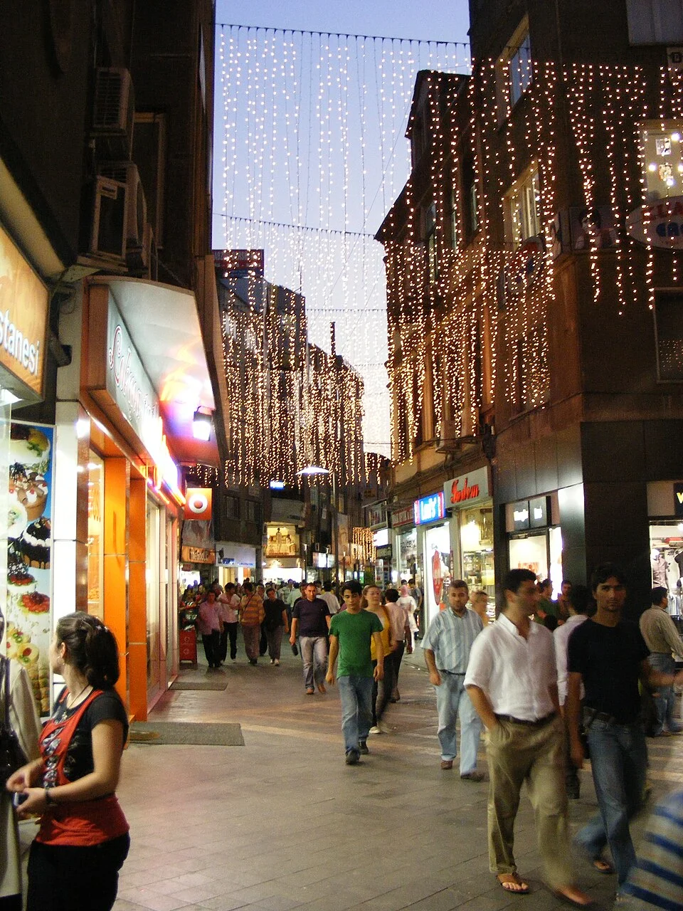 Trabzon Uzun Sokak gece ortamı, Temmuz 2008; görünen tabelalar bugünkü işletme listesi değildir, kişiler şehir bağlamındadır ve destek beyanı değildir.