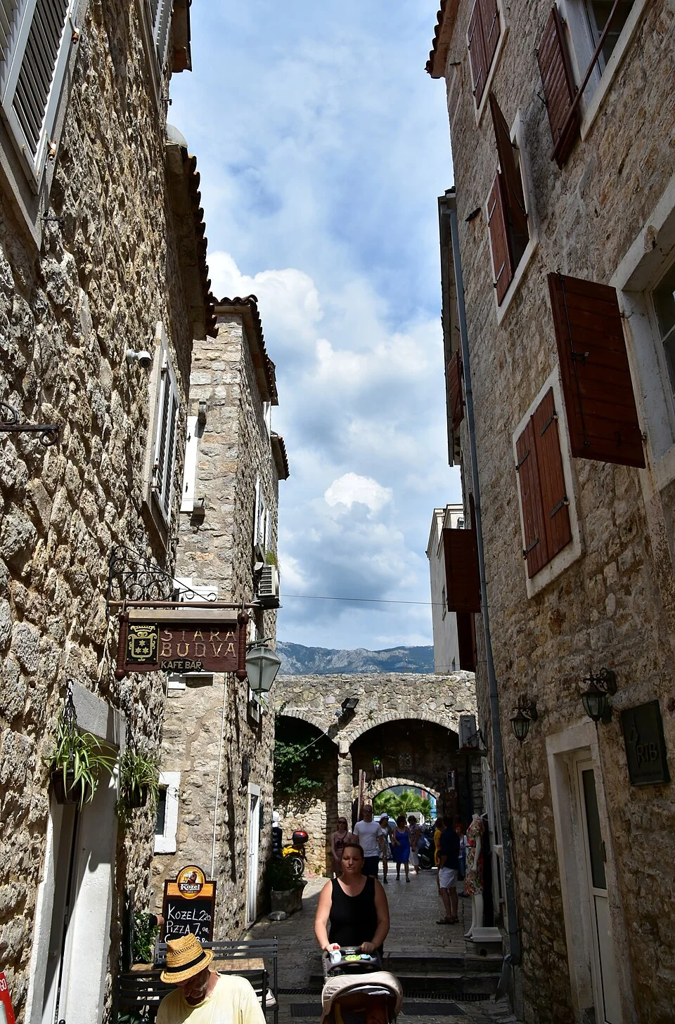 Eski Budva’da dar taş sokak, Eylül 2016; belirli restoranın güncel masa düzenini göstermez.