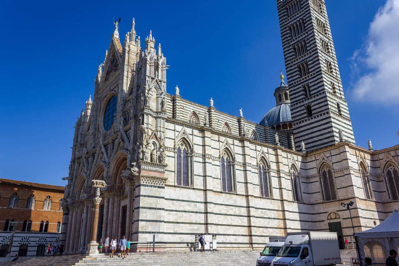 Siena Katedrali süslü ön cephesi ve siyah beyaz çizgili çan kulesi, Temmuz 2014