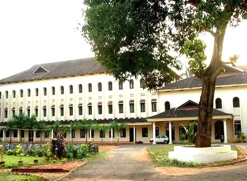 Kottayam Ortodoks İlahiyat Okulunun ağaçlı avluya bakan uzun dış cephesi