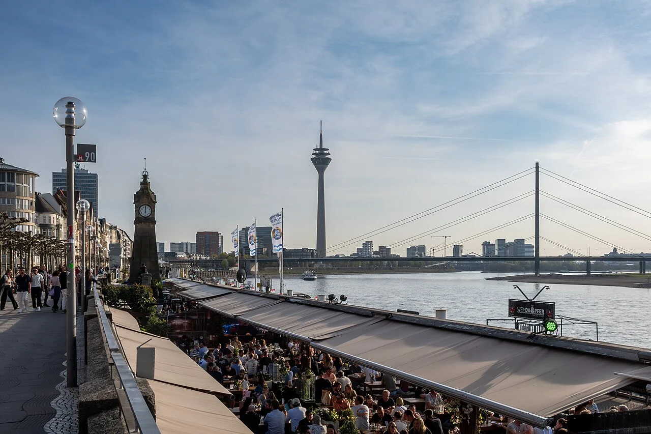 Düsseldorf’s Rhine promenade looking towards Rheinturm and Rheinkniebrücke, photographed in April 2025.