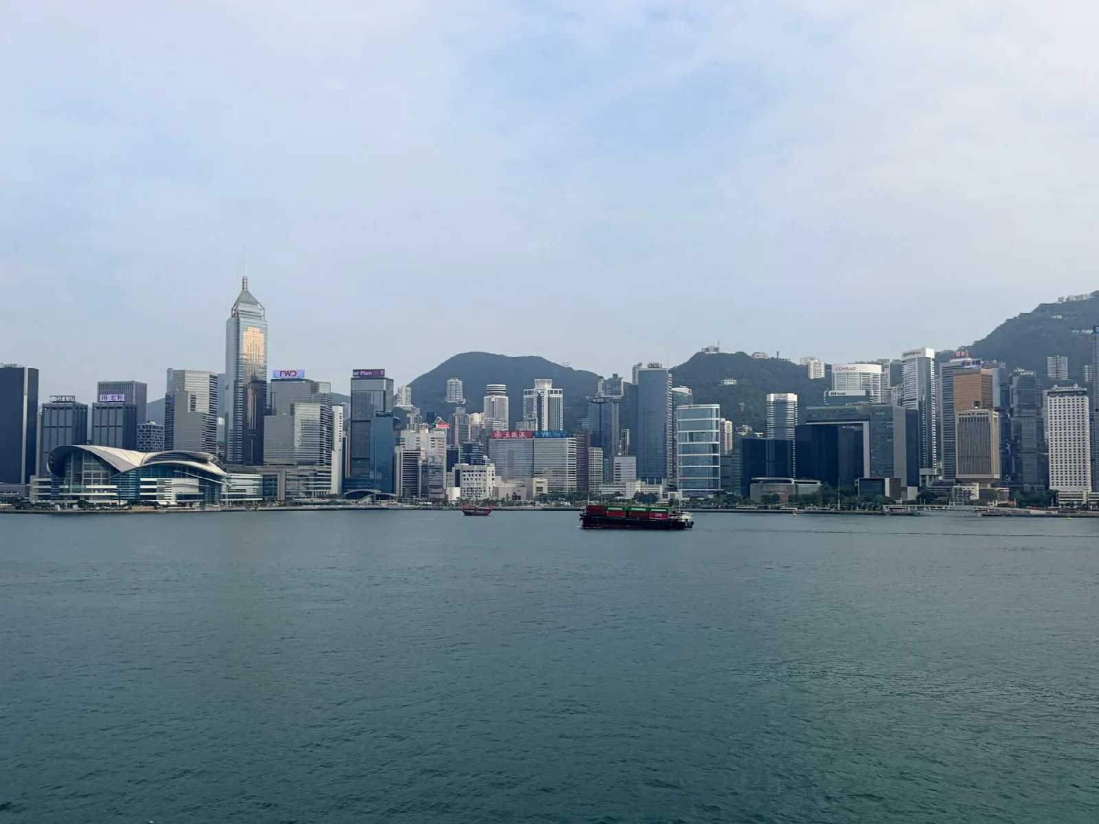 Hong Kong Victoria Harbour suları, kent silueti ve gerisindeki tepeler