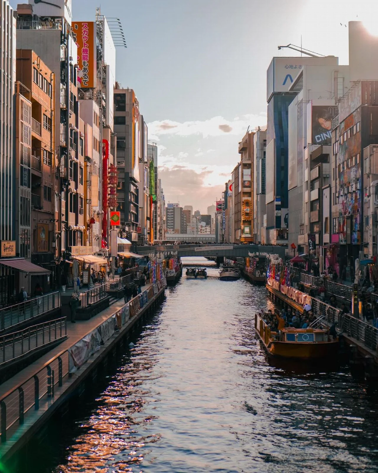 Osaka Dotonbori kanalında tekne ve kıyıdaki şehir yapıları
