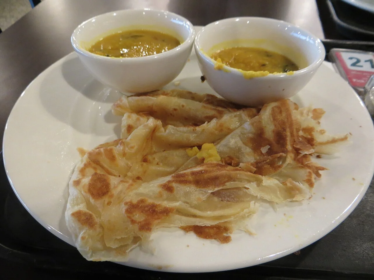 KLIA havaalanında roti canai ve dal, 4 Temmuz 2014; şehir merkezinde restoran tabağı veya güncel terminal menüsü değildir.