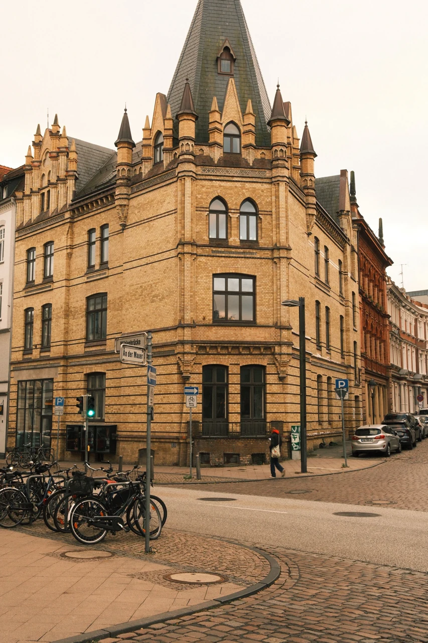 A historic corner building and old-town street in Lübeck
