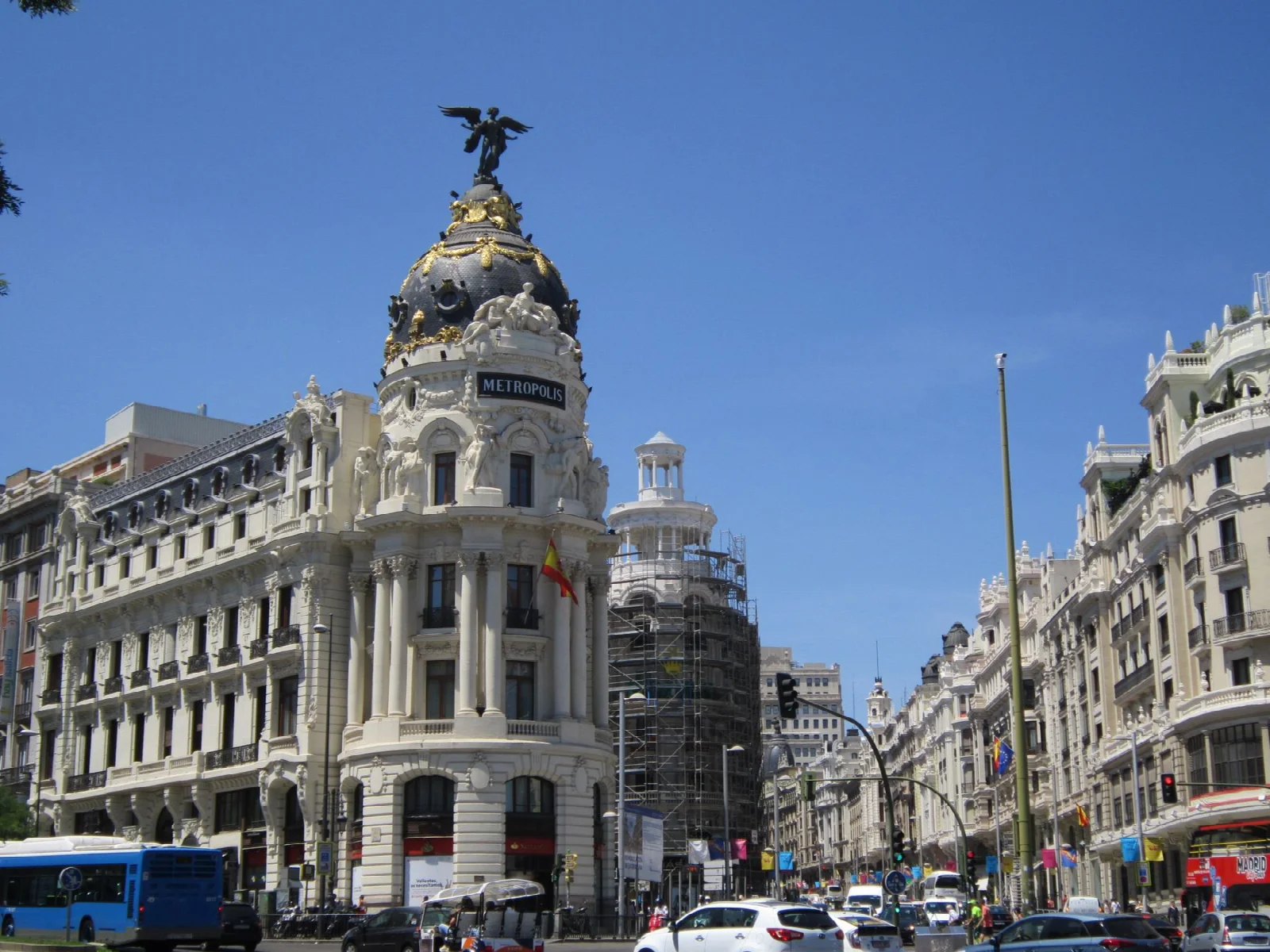 Madrid Gran Vía girişinde Metrópolis binasının kubbesi ve hareketli cadde