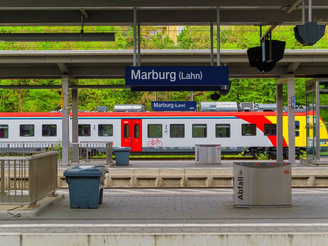 Platform signs and a red train at Marburg (Lahn) station