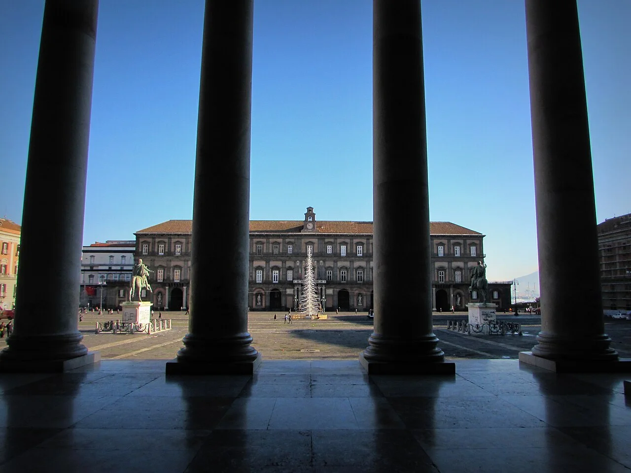 Piazza del Plebiscito and the palace facade in Naples framed by arcade columns; January 2014 photograph.