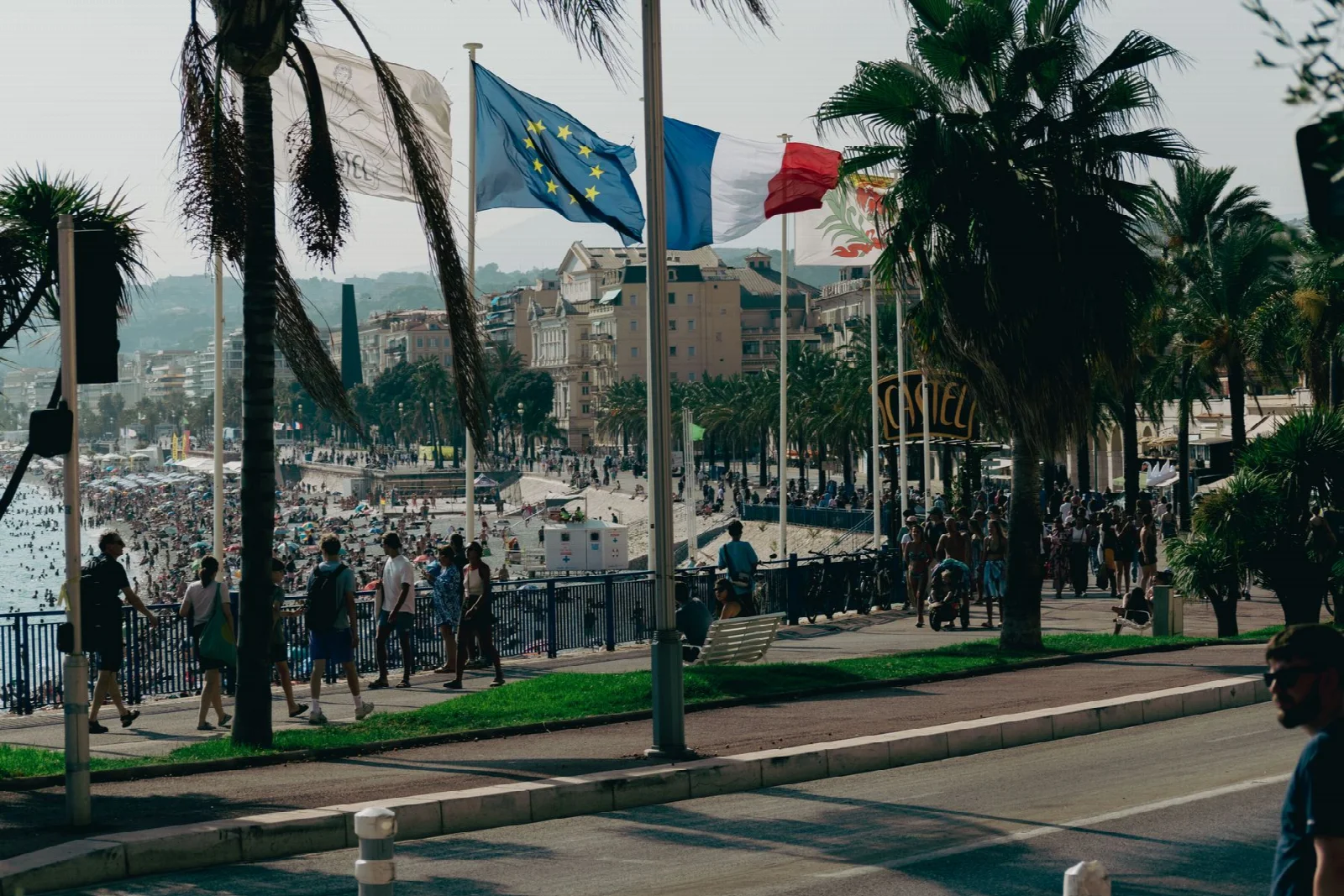 Visitors walking along the seafront promenade in Nice
