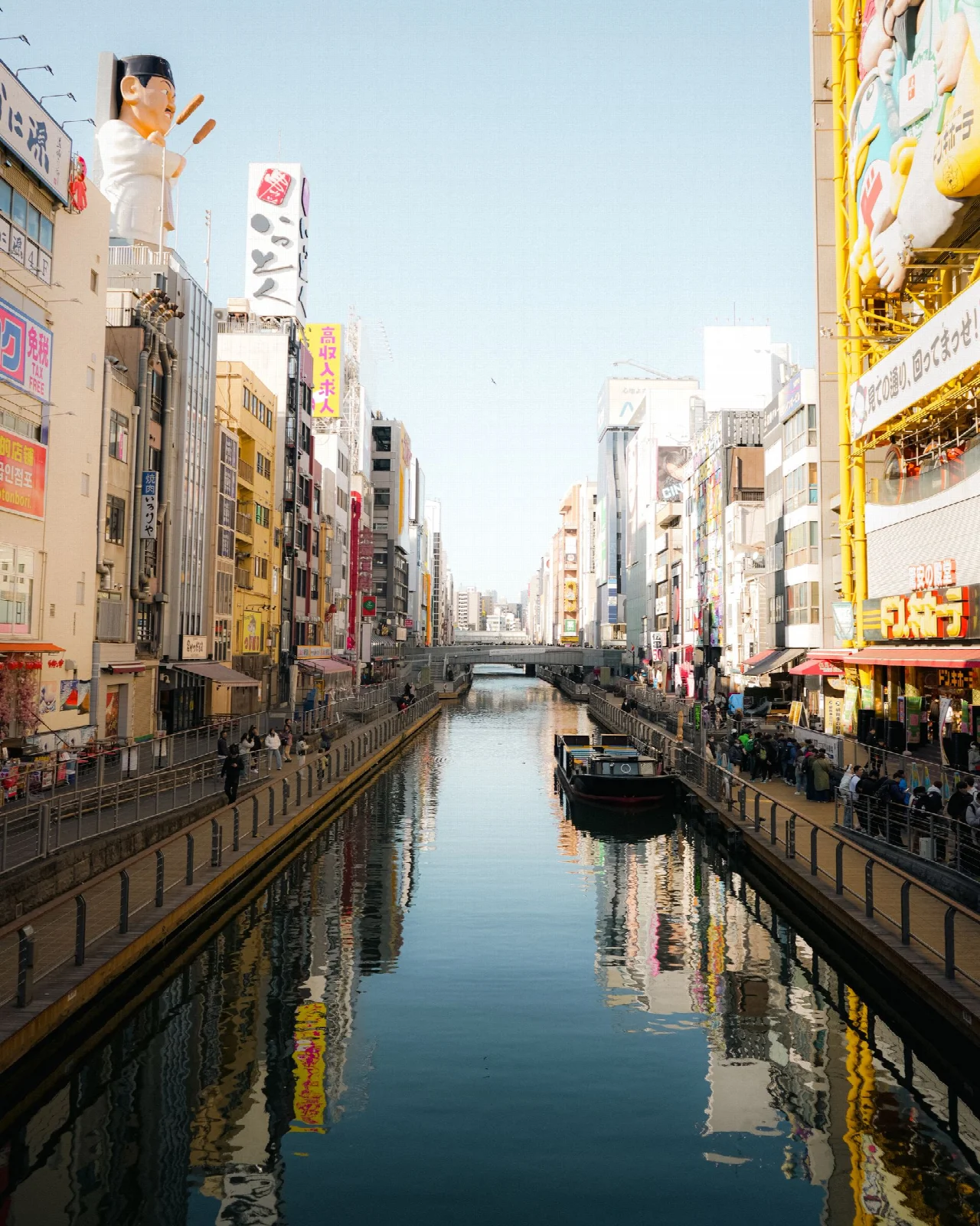 Buildings and signs reflected in the water of Osaka Dotonbori canal