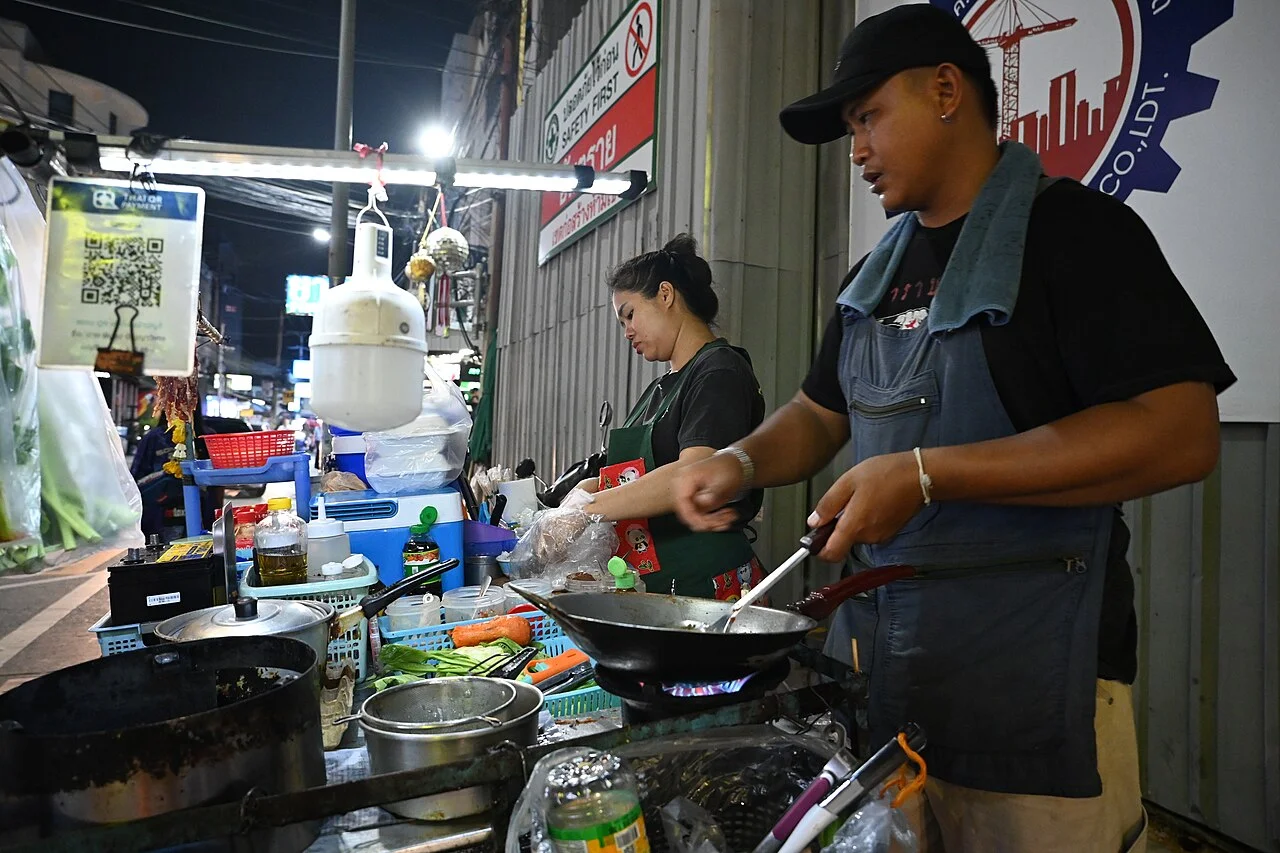 Cooks working at a wok stall in Pattaya city; PattayaPatrol, 15 August 2026. No particular dish identification assigned.