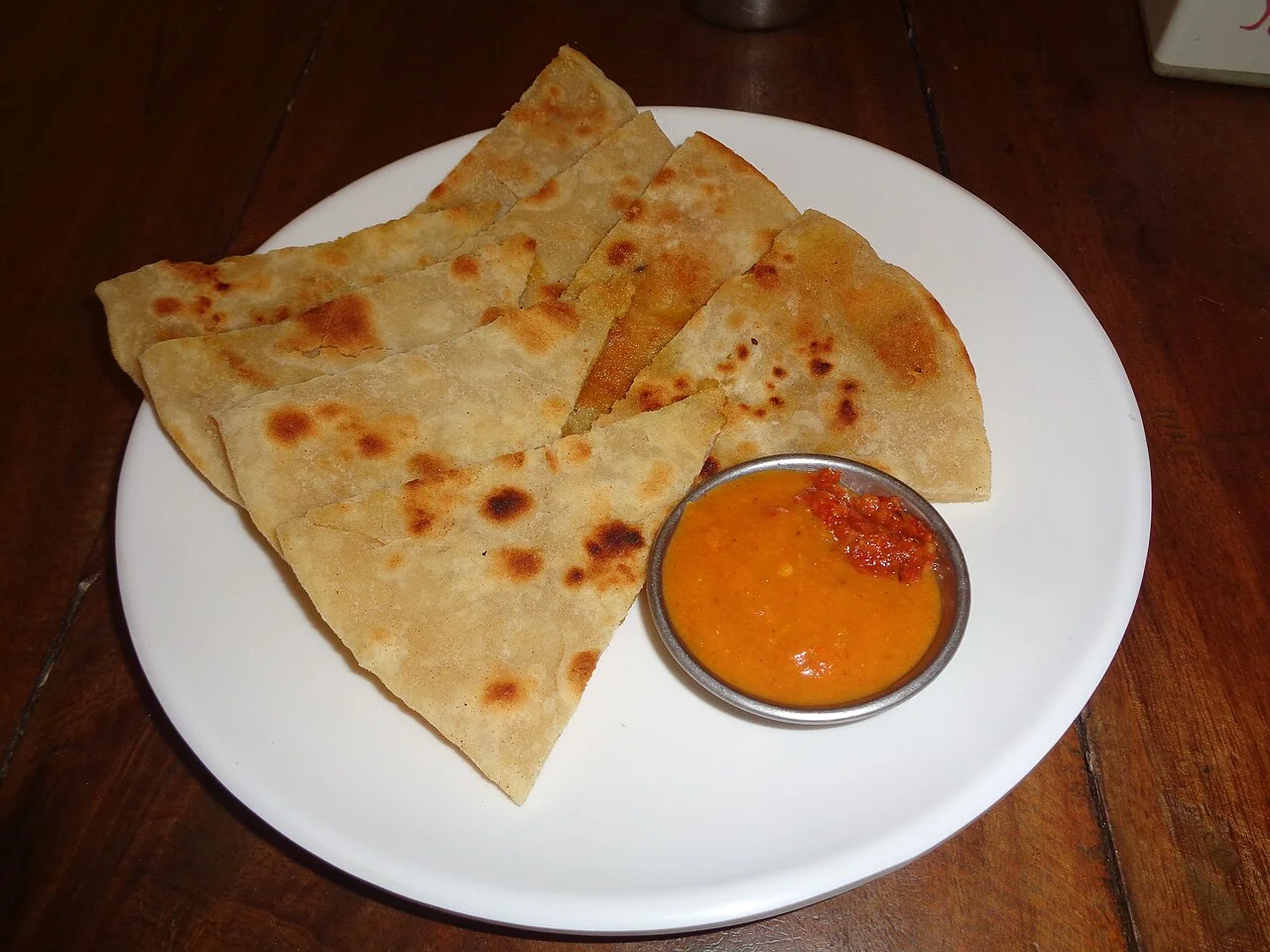 Aloo paratha plate photographed in Pokhara; Виктор Пинчук, 5 March 2026. Exact sauce ingredients and business are not identified.