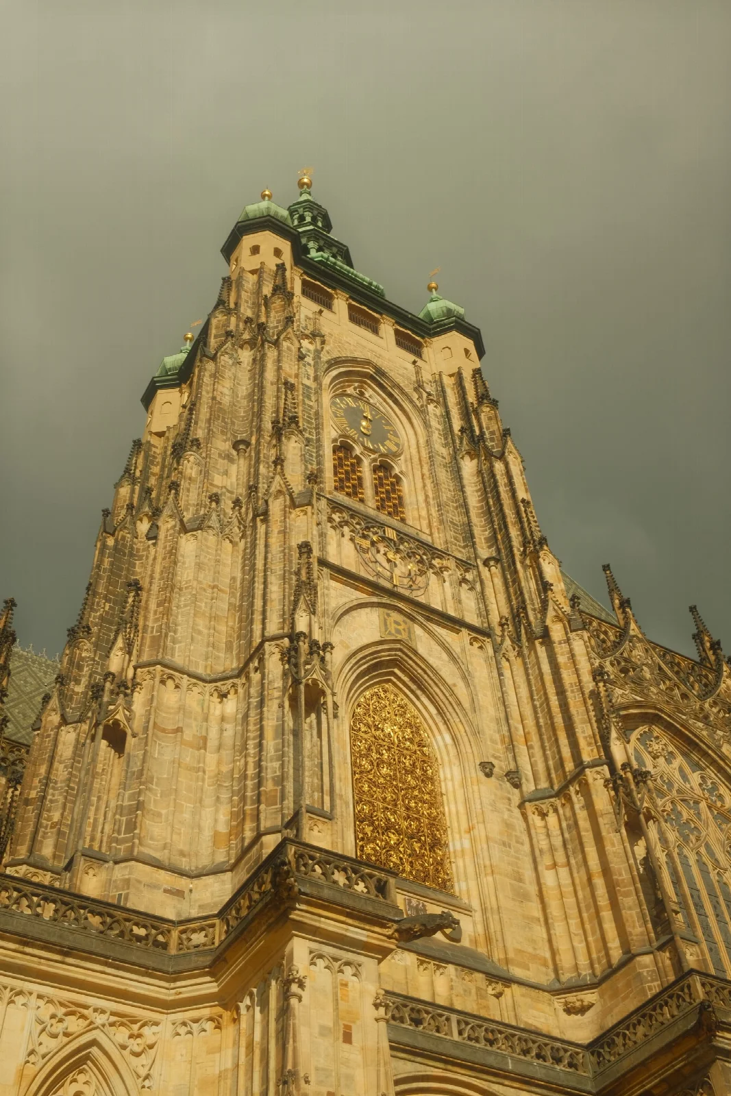 An upward view of a historic cathedral’s intricate Gothic stone façade in Prague