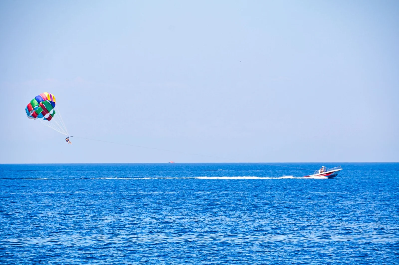 Rodos açıklarında mavi deniz üzerinde tekne ve deniz paraşütü