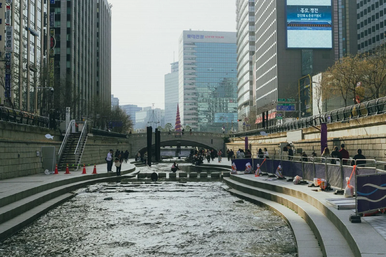 Waterside walk along Cheonggyecheon in central Seoul; authentic city context, not a restaurant-table view.