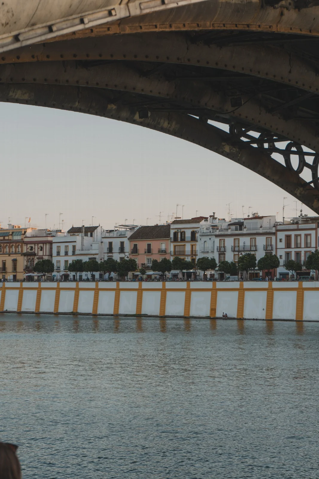 A view beneath a bridge arch towards the Triana riverfront in Seville