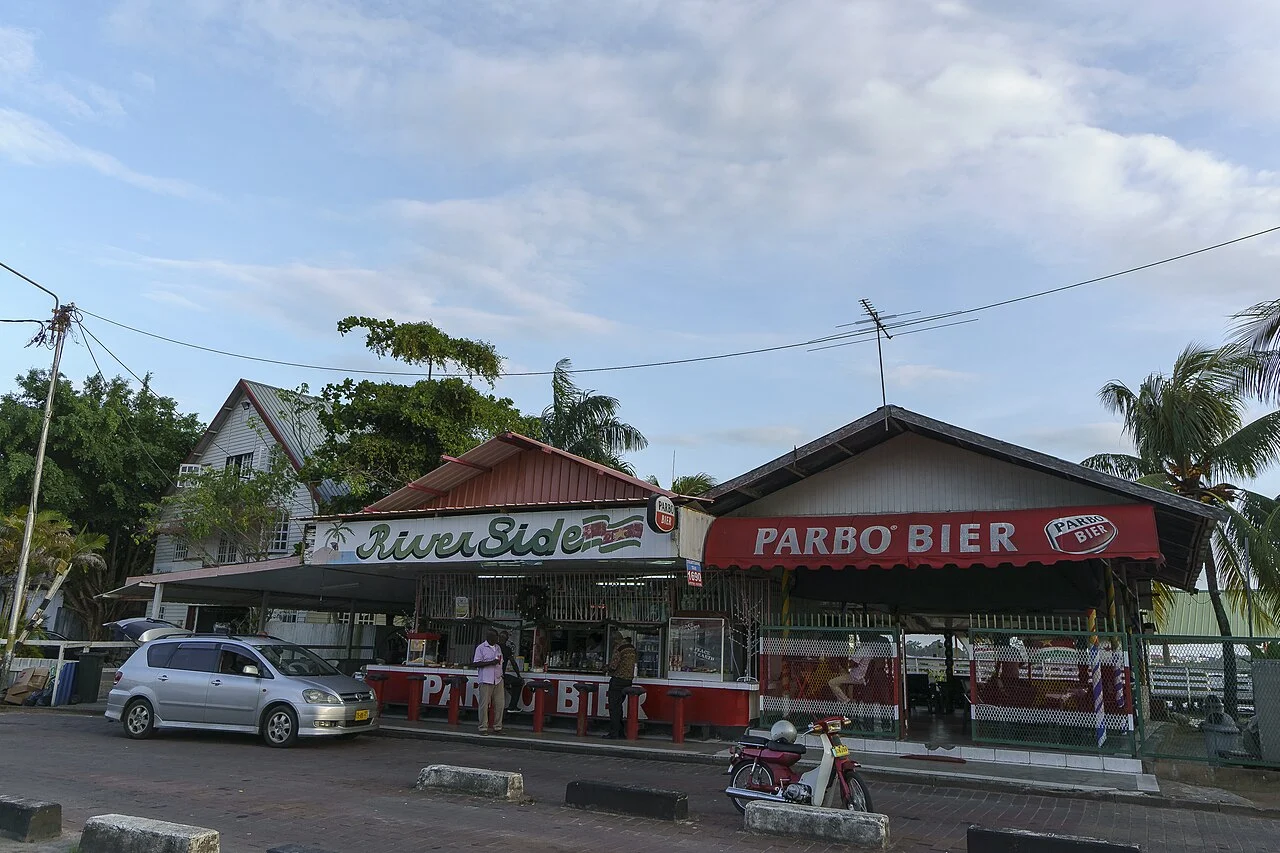 Paramaribo merkezindeki nehir kıyısı çevresinde ticari sokak cephesi, 2015; güncel işletme önerisi değildir