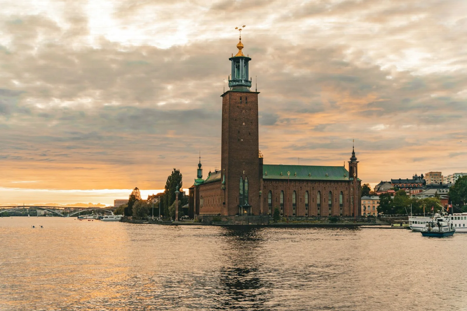 Stockholm Belediye Binası’nın gün batımında suya yansıyan silueti