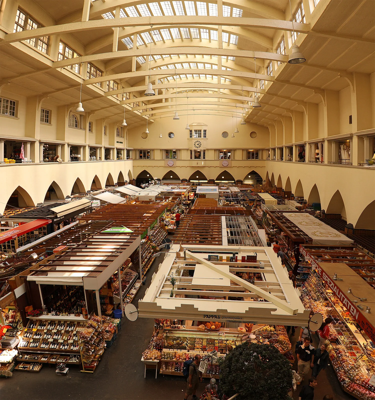 Stuttgart Markthalle kapalı pazarında tezgâhların sıralandığı yüksek tavanlı iç mekân