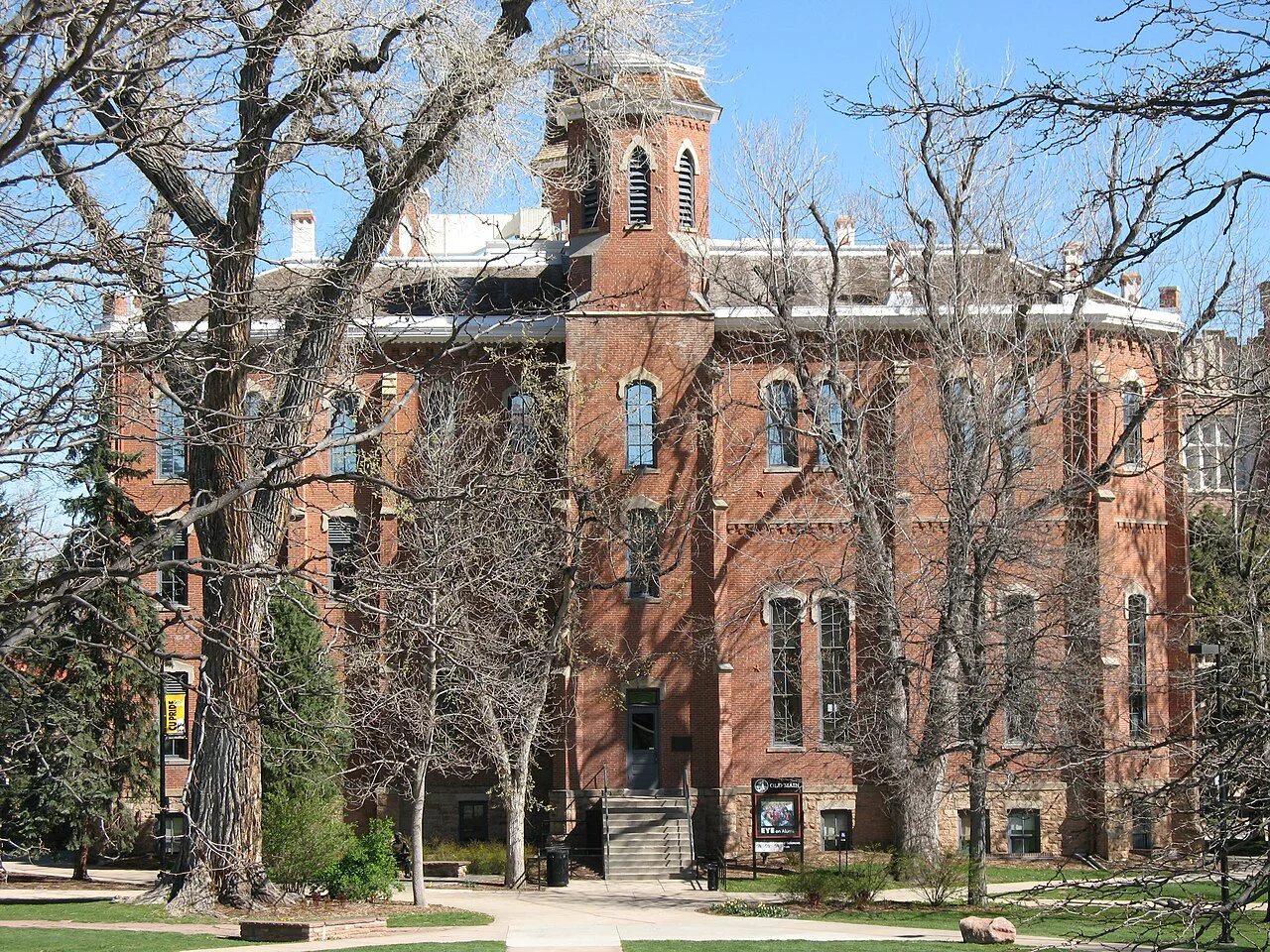 CU Boulder Old Main brick frontage, tower and foreground trees, April 2007; not current campus interior access
